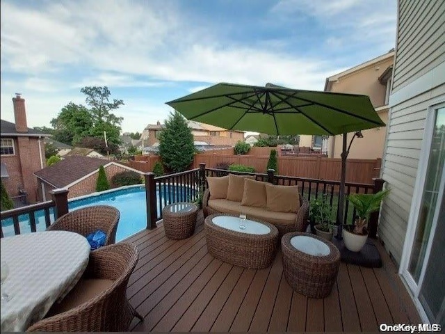 wooden terrace featuring outdoor lounge area and a fenced in pool