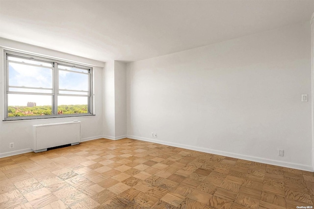 unfurnished room featuring radiator heating unit