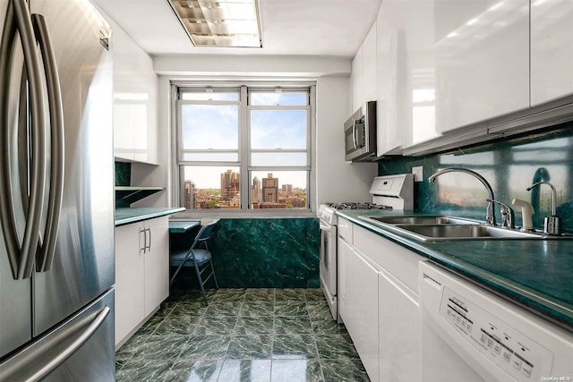 kitchen with sink, white cabinets, and stainless steel appliances