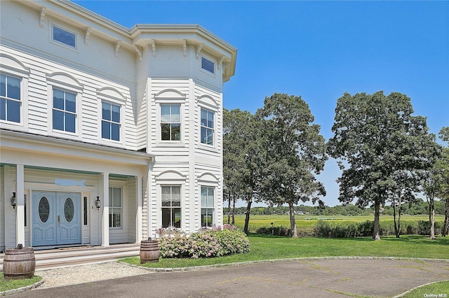 italianate-style house with covered porch and a front yard