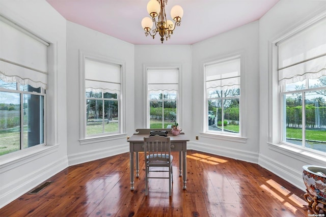 dining area featuring a notable chandelier, dark hardwood / wood-style floors, and a healthy amount of sunlight