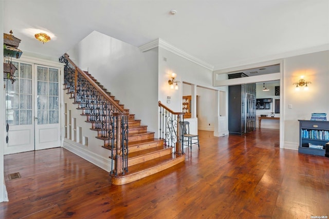 stairs with crown molding, french doors, and wood-type flooring