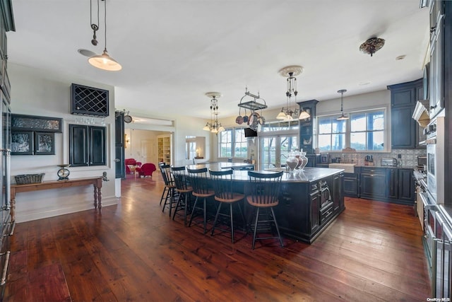 kitchen featuring dark hardwood / wood-style floors, a center island, and hanging light fixtures