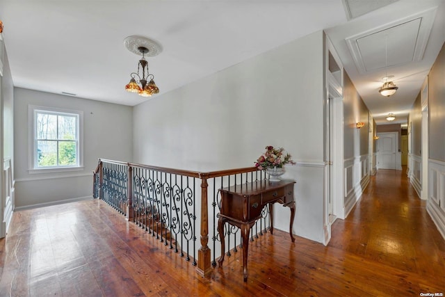 hall with dark hardwood / wood-style floors and an inviting chandelier