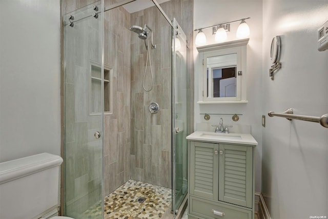 bathroom featuring an enclosed shower, vanity, and toilet