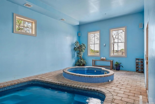 view of swimming pool with an indoor hot tub