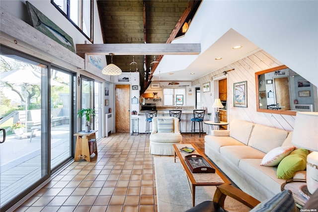 tiled living room with wood walls, wooden ceiling, beam ceiling, and high vaulted ceiling