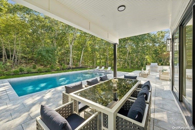 view of swimming pool featuring area for grilling and a patio area