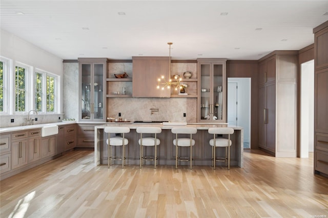 kitchen with a kitchen bar, light hardwood / wood-style floors, decorative light fixtures, and a notable chandelier