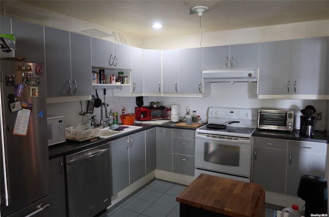 kitchen featuring gray cabinets, light tile patterned floors, sink, and appliances with stainless steel finishes