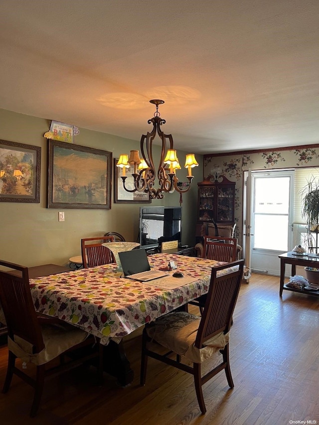 dining room with hardwood / wood-style floors and a chandelier