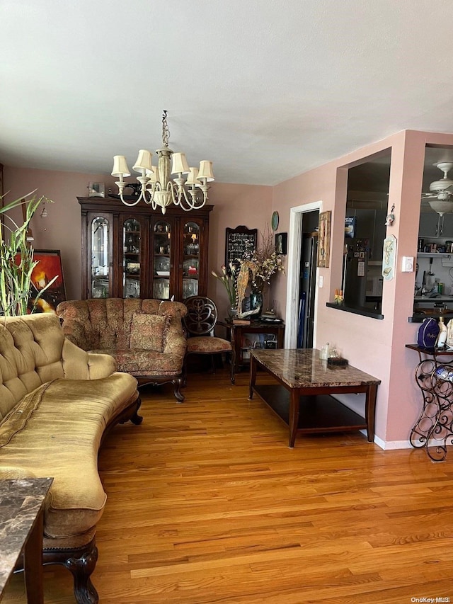 living room featuring a chandelier and light wood-type flooring