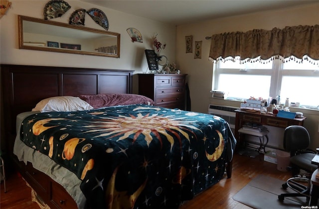 bedroom featuring a wall mounted AC and hardwood / wood-style floors