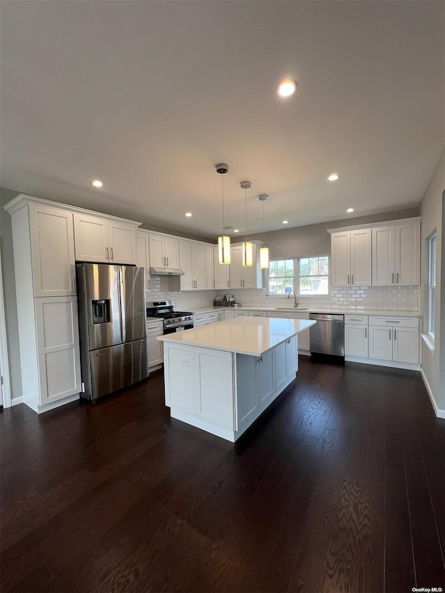 kitchen featuring pendant lighting, a center island, appliances with stainless steel finishes, dark hardwood / wood-style flooring, and white cabinetry