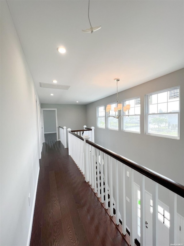 hall with a chandelier and dark hardwood / wood-style floors