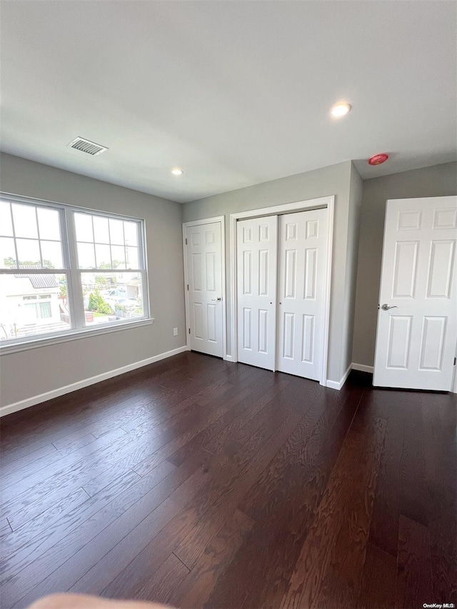 unfurnished bedroom with dark hardwood / wood-style floors