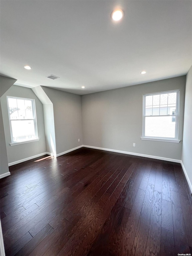 unfurnished room featuring dark hardwood / wood-style flooring and a wealth of natural light