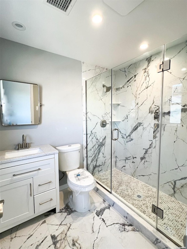 bathroom with vanity, a shower with shower door, and toilet