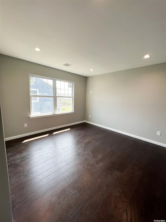 empty room with dark hardwood / wood-style flooring