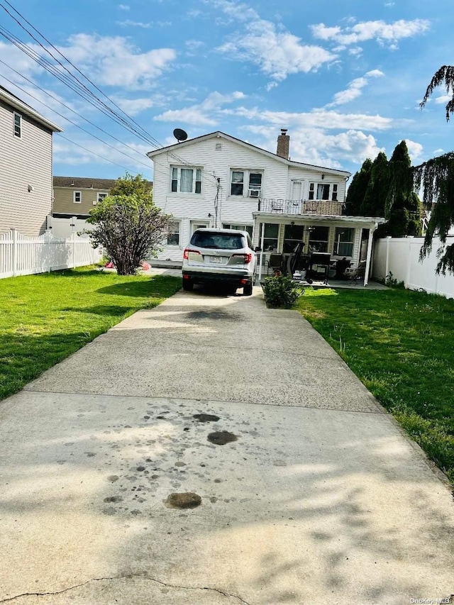 view of front of home featuring a balcony and a front lawn