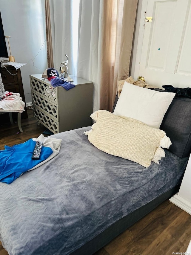 bedroom with dark hardwood / wood-style flooring