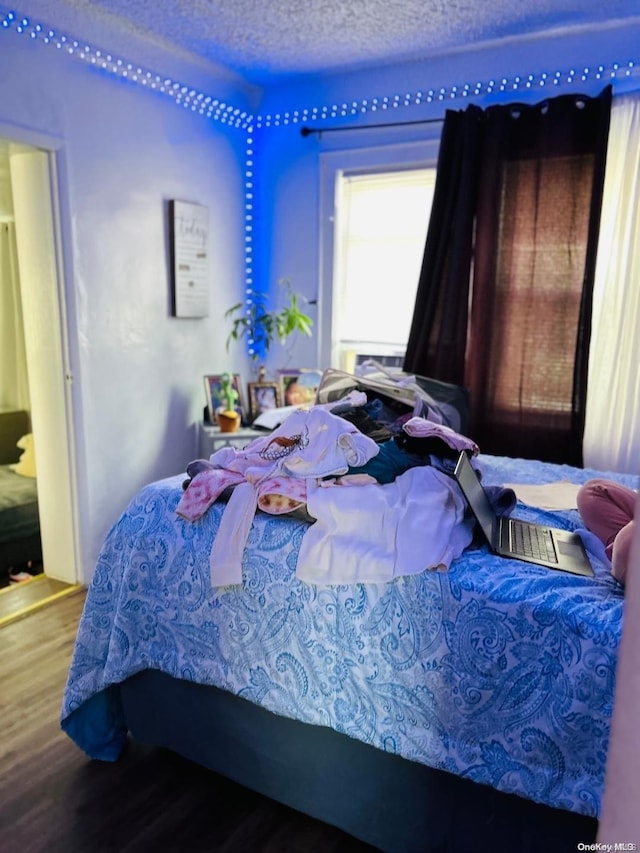 bedroom featuring a textured ceiling and hardwood / wood-style flooring