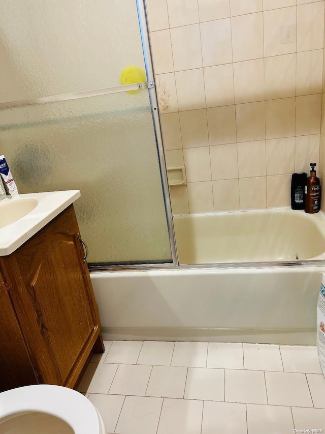 full bathroom featuring tile patterned floors, vanity, toilet, and enclosed tub / shower combo