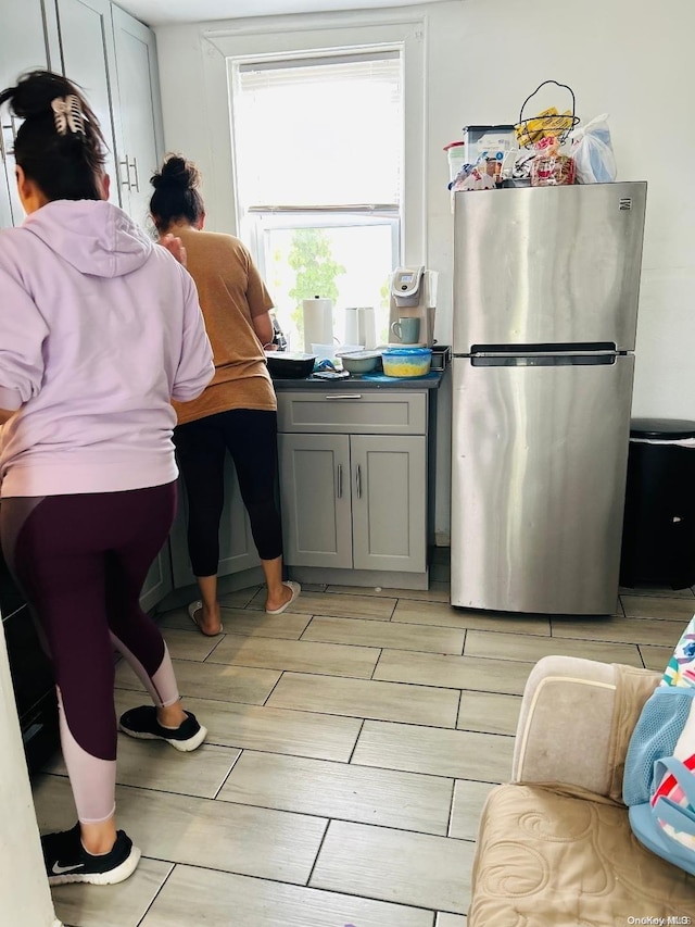 kitchen featuring gray cabinets, stainless steel fridge, and light hardwood / wood-style flooring