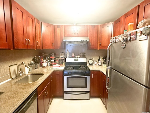 kitchen featuring light stone countertops, backsplash, stainless steel appliances, and sink