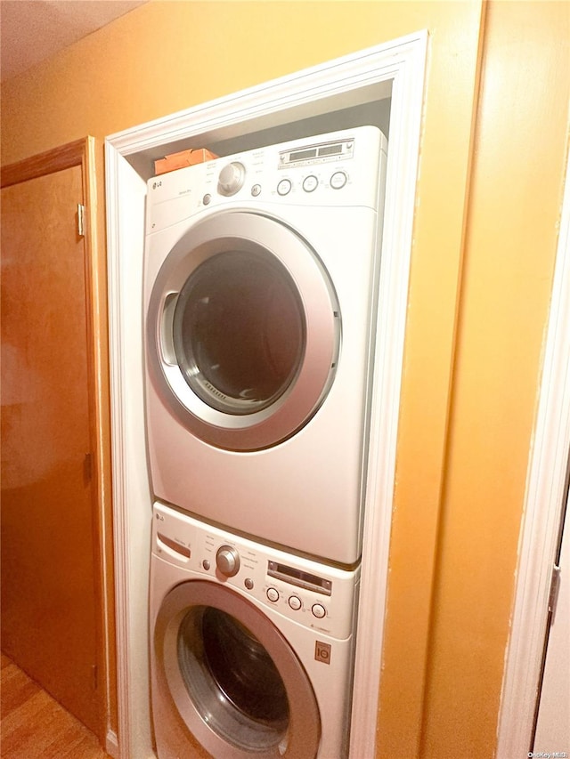 clothes washing area with stacked washer and dryer