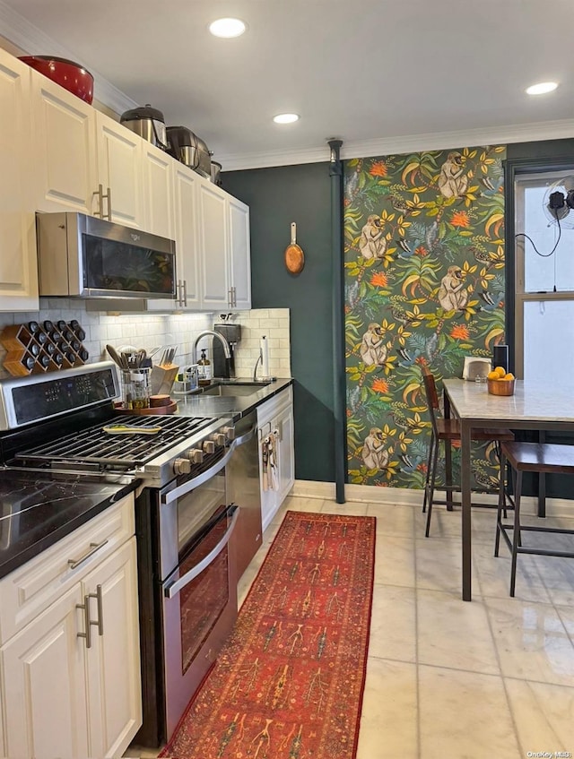 kitchen with sink, stainless steel appliances, white cabinets, crown molding, and light tile patterned flooring