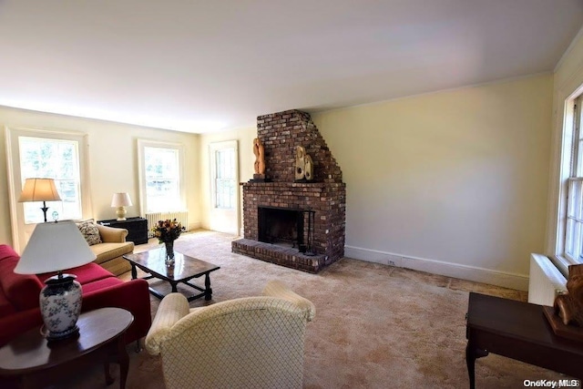 carpeted living room with radiator and a brick fireplace