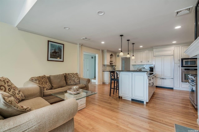 living room featuring crown molding and light hardwood / wood-style floors