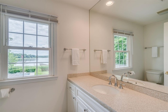 bathroom with vanity, a water view, and toilet