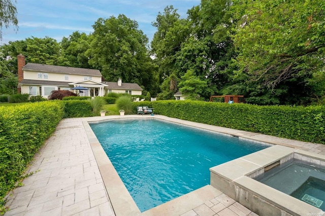 view of swimming pool featuring an in ground hot tub