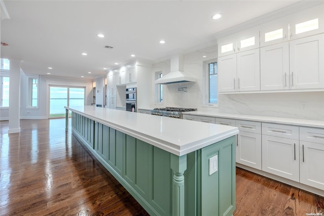 kitchen with premium range hood, decorative backsplash, white cabinetry, and dark wood-type flooring