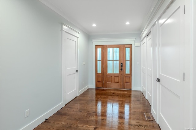 foyer entrance featuring crown molding and dark wood-type flooring