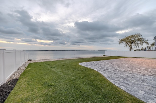 view of yard with a water view and a patio area