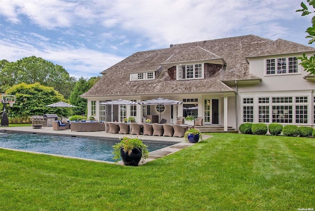 rear view of property featuring outdoor lounge area, a patio area, and a lawn