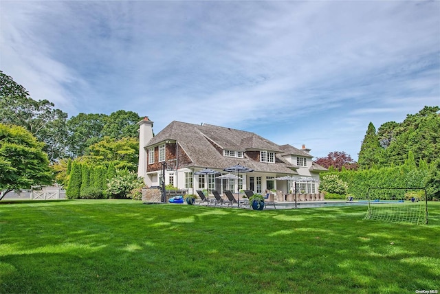 rear view of property with a patio and a lawn