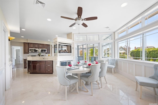 dining area featuring ceiling fan and sink