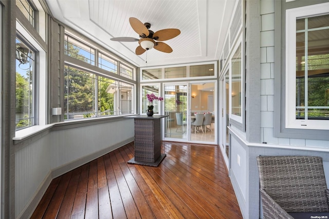 unfurnished sunroom featuring plenty of natural light, ceiling fan, and a raised ceiling