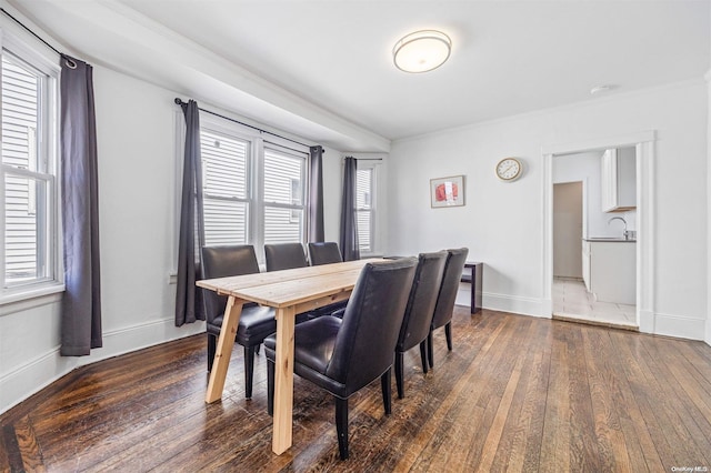 dining room with sink, dark wood-type flooring, and ornamental molding