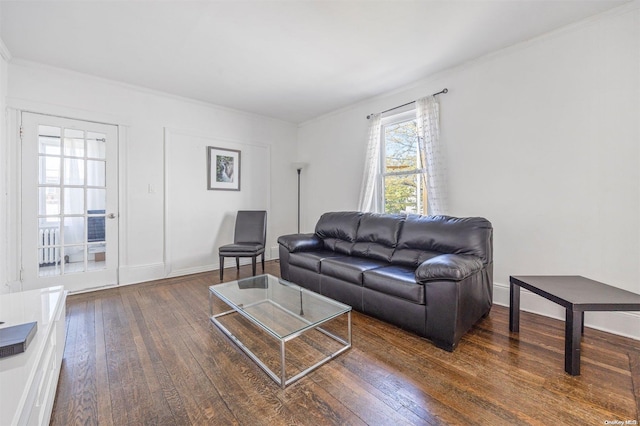 living room with dark hardwood / wood-style flooring and ornamental molding