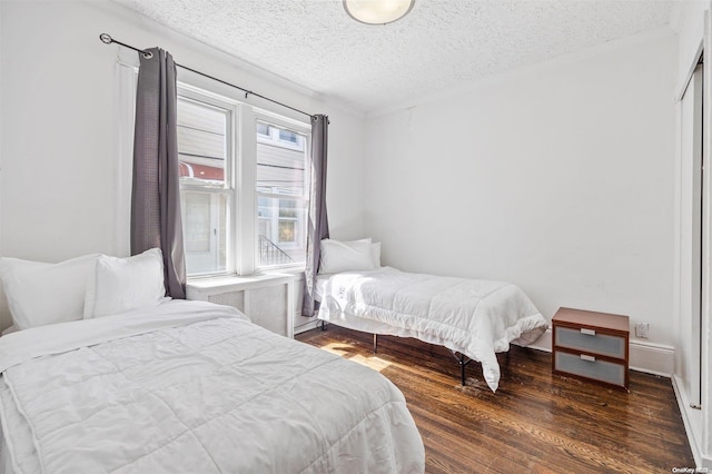 bedroom with dark hardwood / wood-style flooring and a textured ceiling