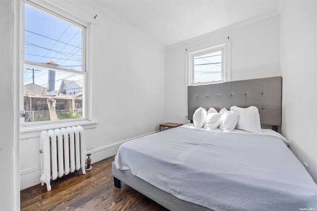 bedroom with dark hardwood / wood-style floors, radiator, and crown molding