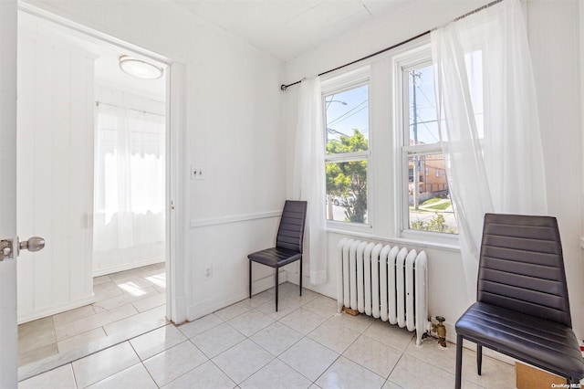 living area featuring radiator heating unit, light tile patterned flooring, and ornamental molding