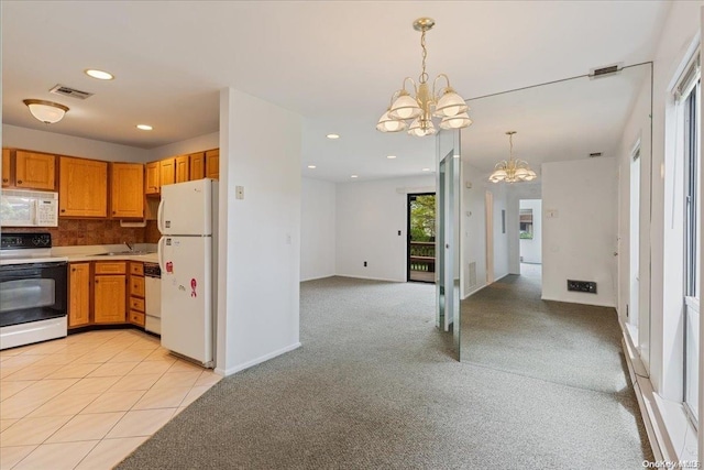 kitchen featuring decorative light fixtures, light colored carpet, white appliances, and a notable chandelier