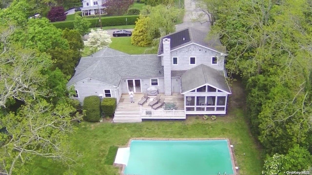 rear view of house with a lawn, a wooden deck, and a sunroom