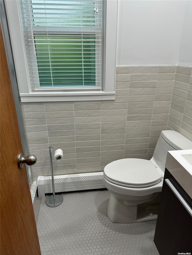 bathroom with tile patterned floors, vanity, a baseboard heating unit, tile walls, and toilet